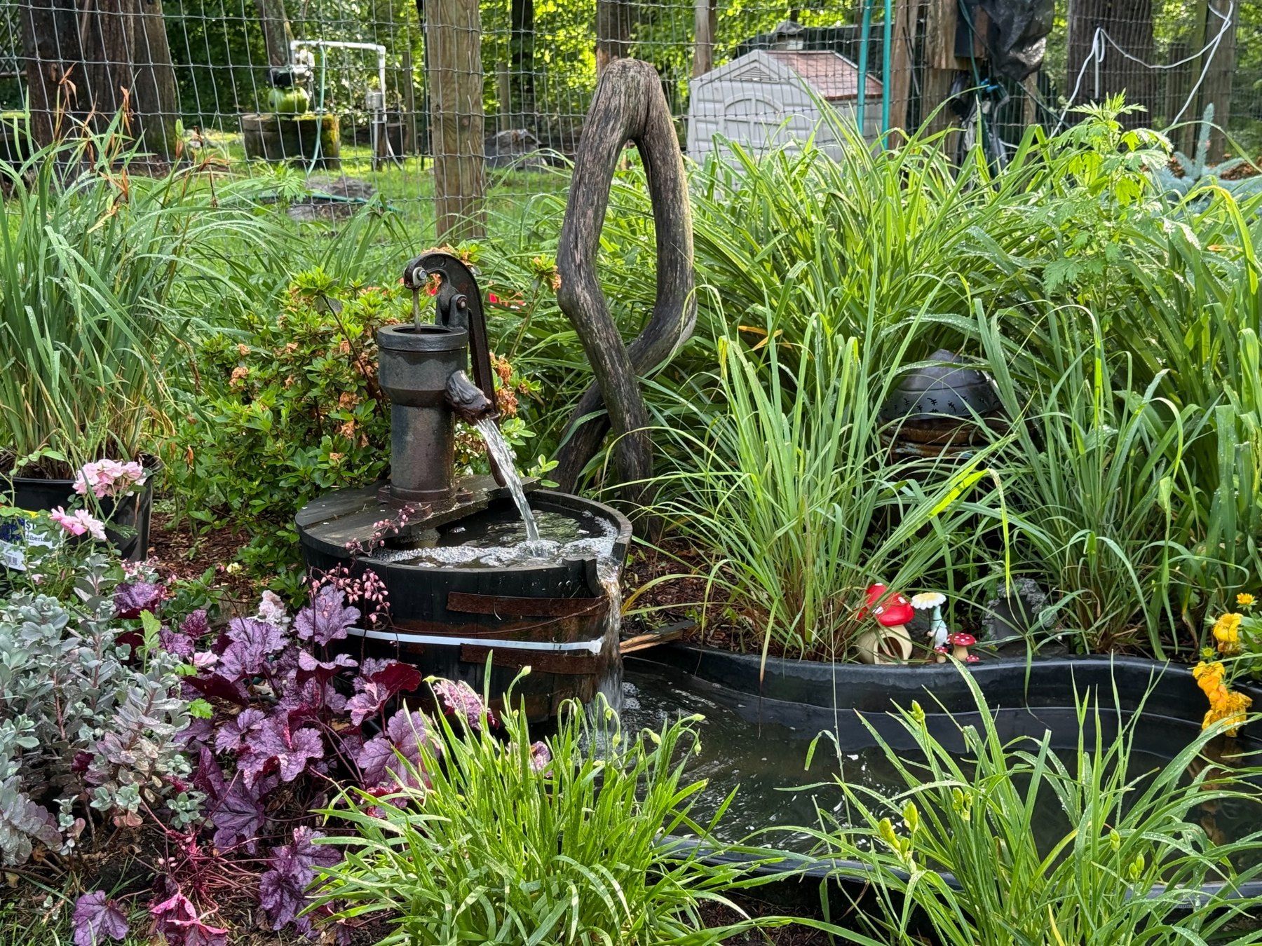 Decorative water feature among colorful garden plants