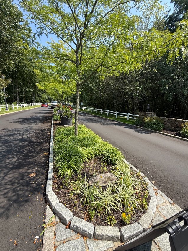 Stone edging installed by County Grounds & Company defines the roadside planting area.