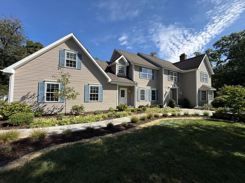 Planting beds and a stone walkway frame the front of a home.